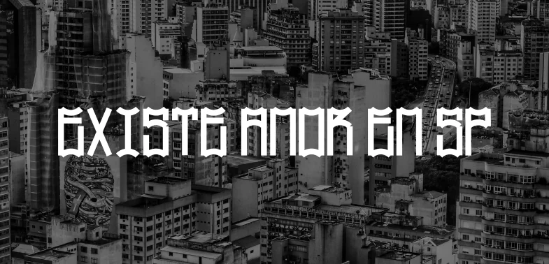 A frase EXISTE AMOR EM SP em branco, composta em Mosquito sobre vista aérea em preto e branco de prédios de São Paulo.